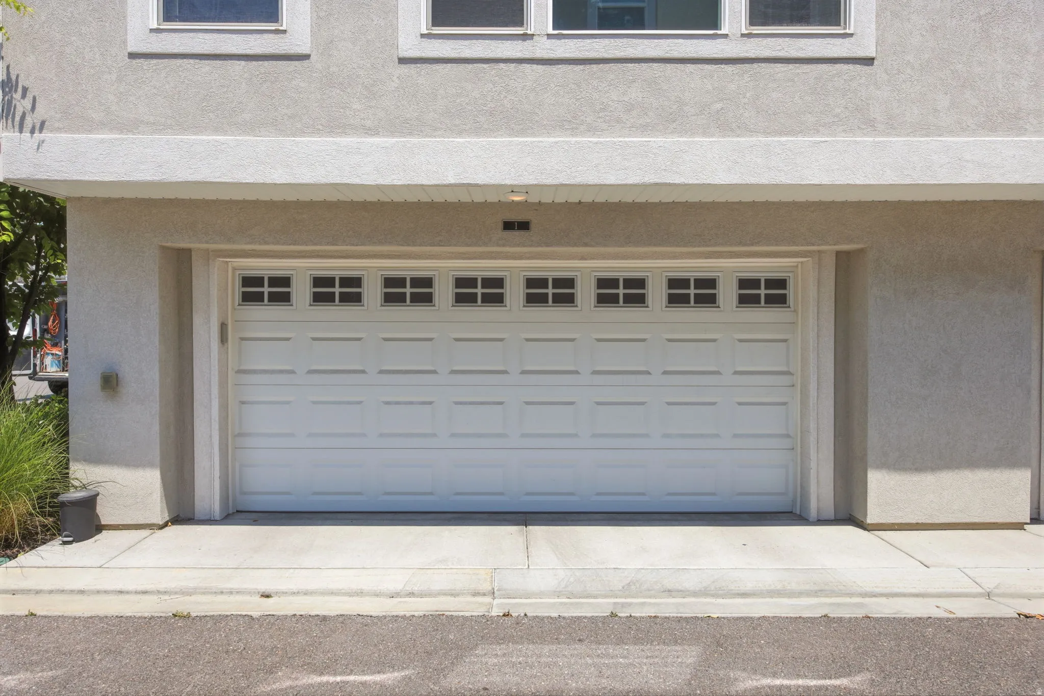 Two-car garage with a paneled white door and upper window inserts