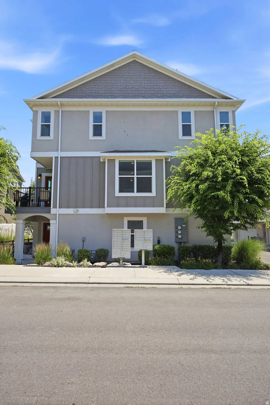 Three-story residence featuring a combination of stucco and horizontal siding, with a distinct gable roofline