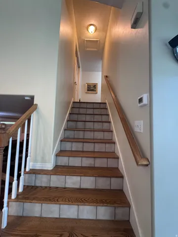Staircase featuring wood-finish treads and tiled risers