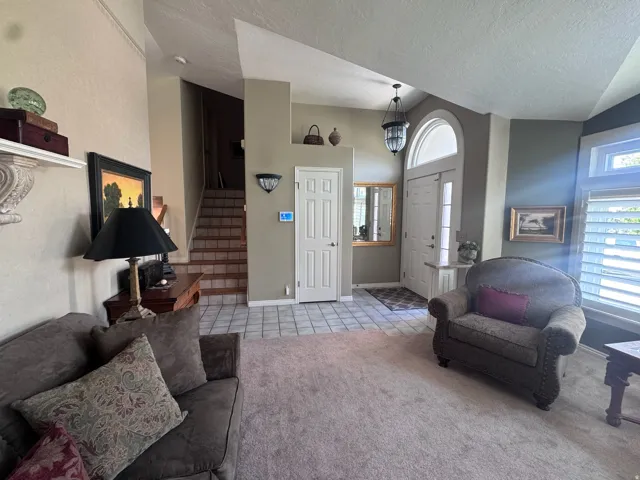 Foyer entry with a tiled floor, double entry door with an arched transom window, and a chandelier light fixture