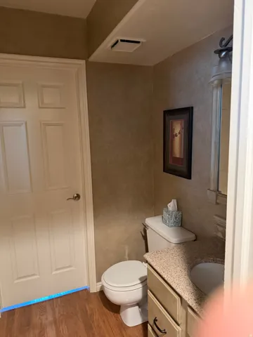 Wood-finish flooring with a white six-panel door