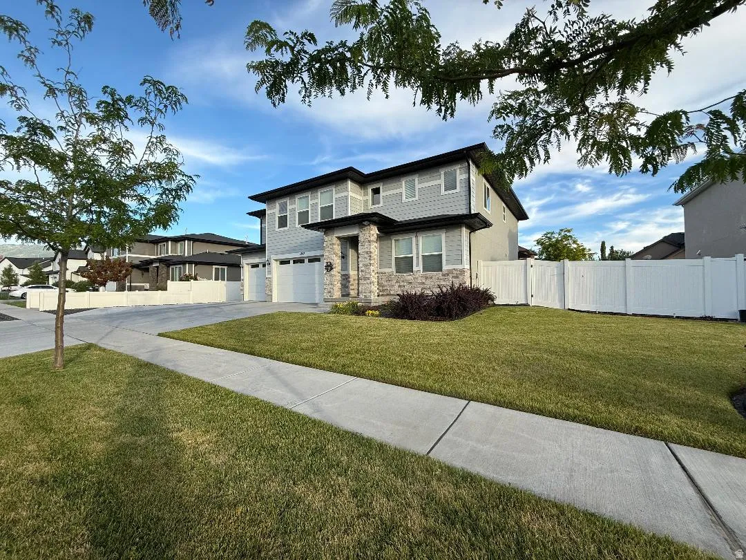 Modern two-story residence featuring a stone and siding exterior