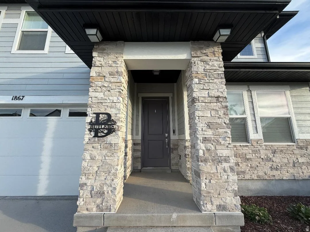 Stone veneer columns framing a covered entryway with a dark paneled door