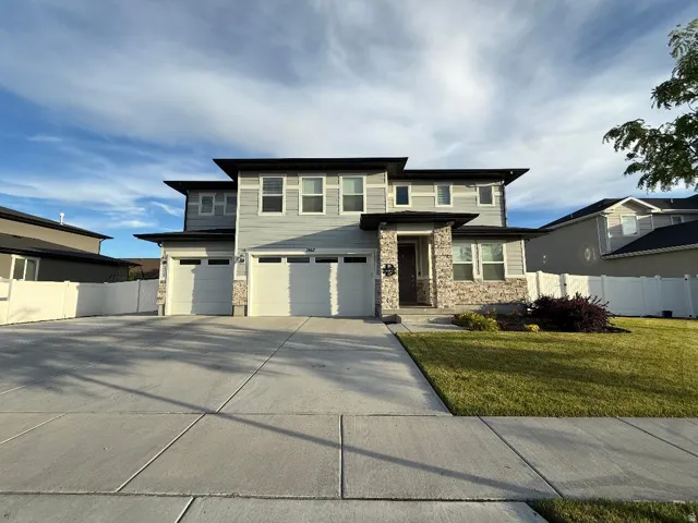 Contemporary residence featuring light grey siding and stone veneer accents