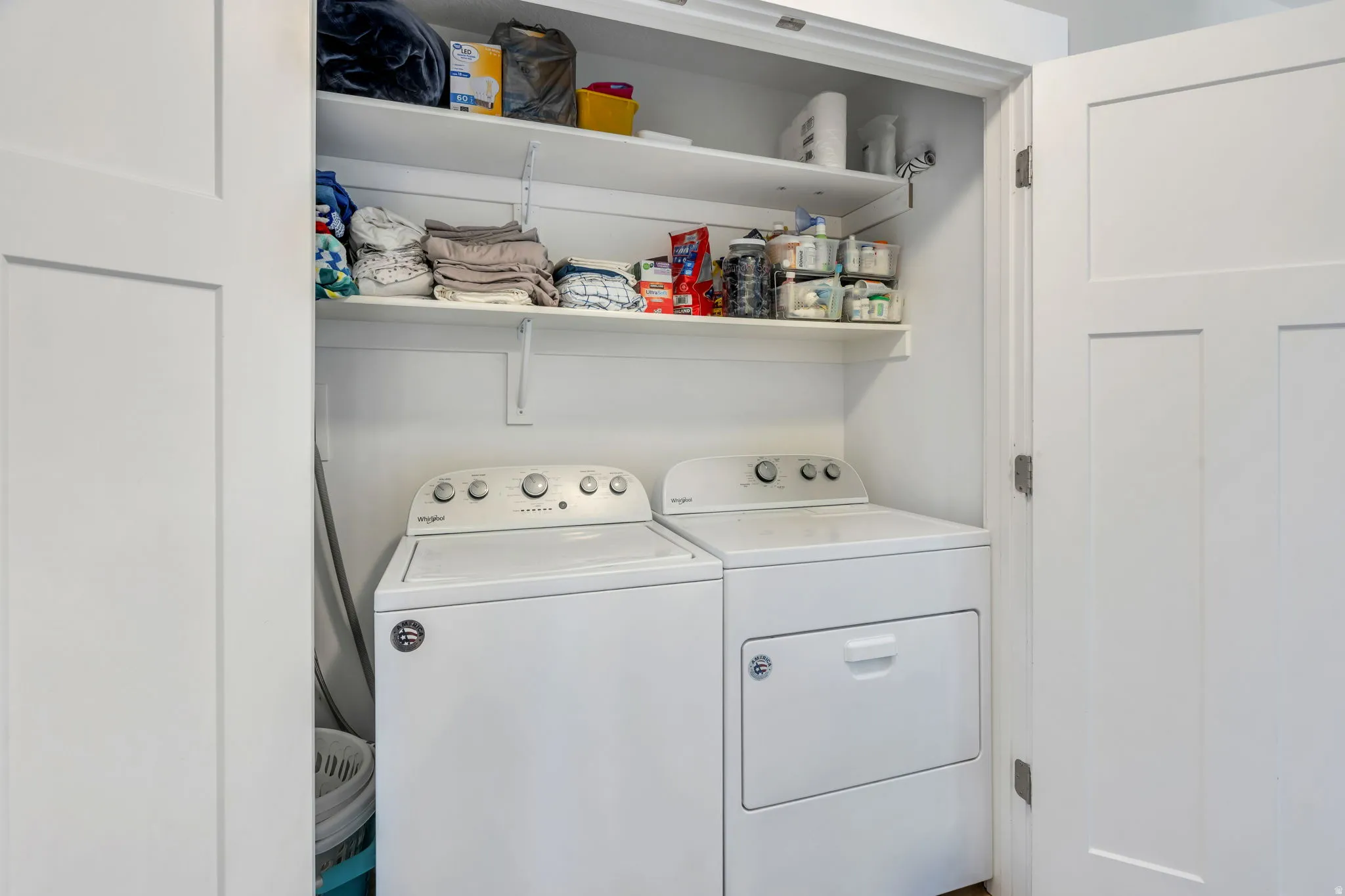 Second level laundry with white panel doors, and two levels of open shelving