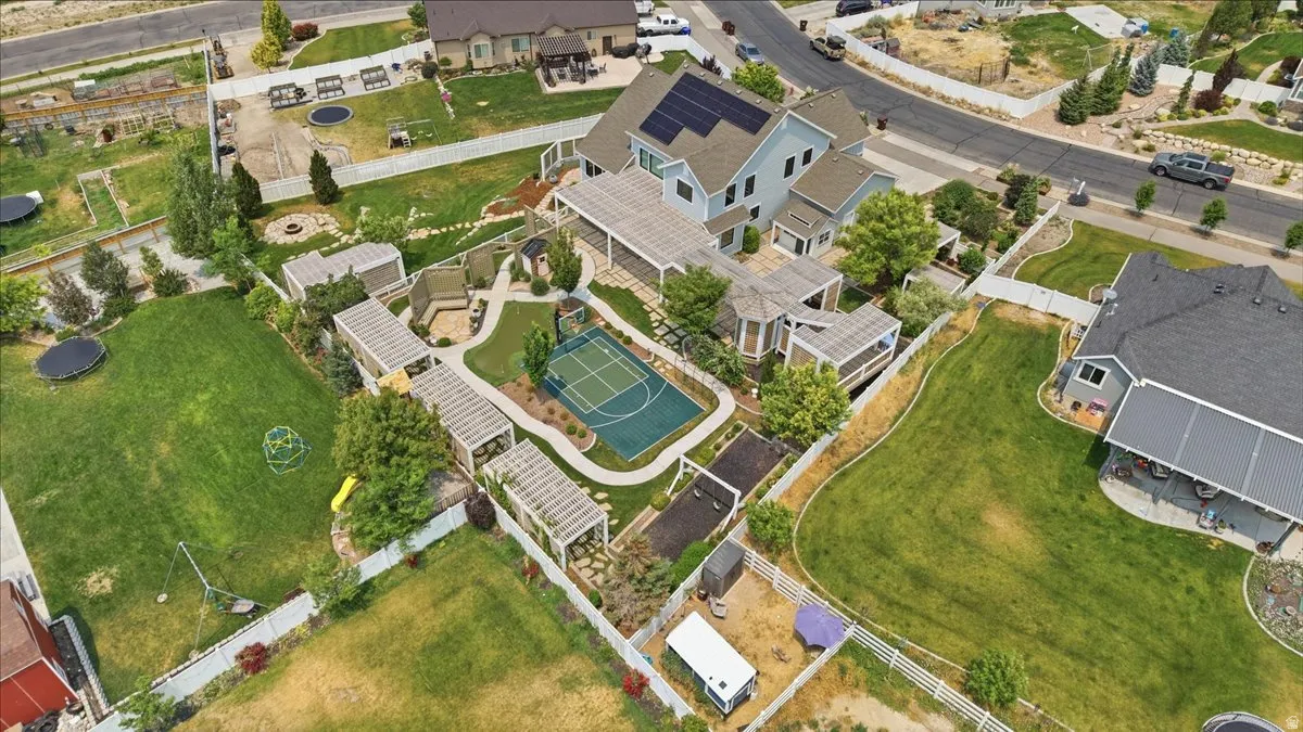 Expansive property featuring a multi-sport court, multiple pergolas, and a dedicated fire pit area