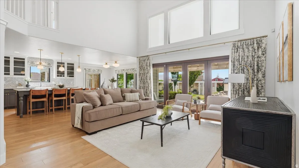 Open-concept living space featuring high ceilings, wood-finish flooring, and large sliding glass doors