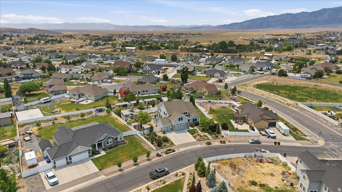 Expansive residential area featuring a variety of single-family homes, mature landscaping, paved roads, and distant mountain ranges