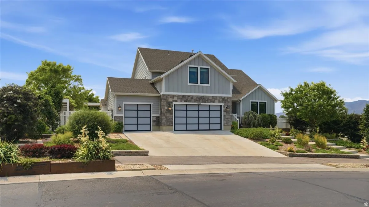 Contemporary residence featuring light grey siding and stone veneer accents