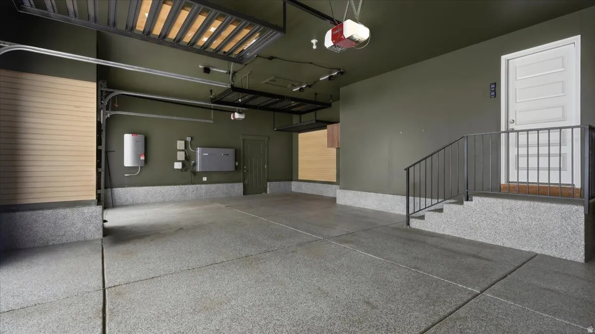 Garage featuring an epoxy-coated concrete floor, neutral-toned walls, and overhead storage racks