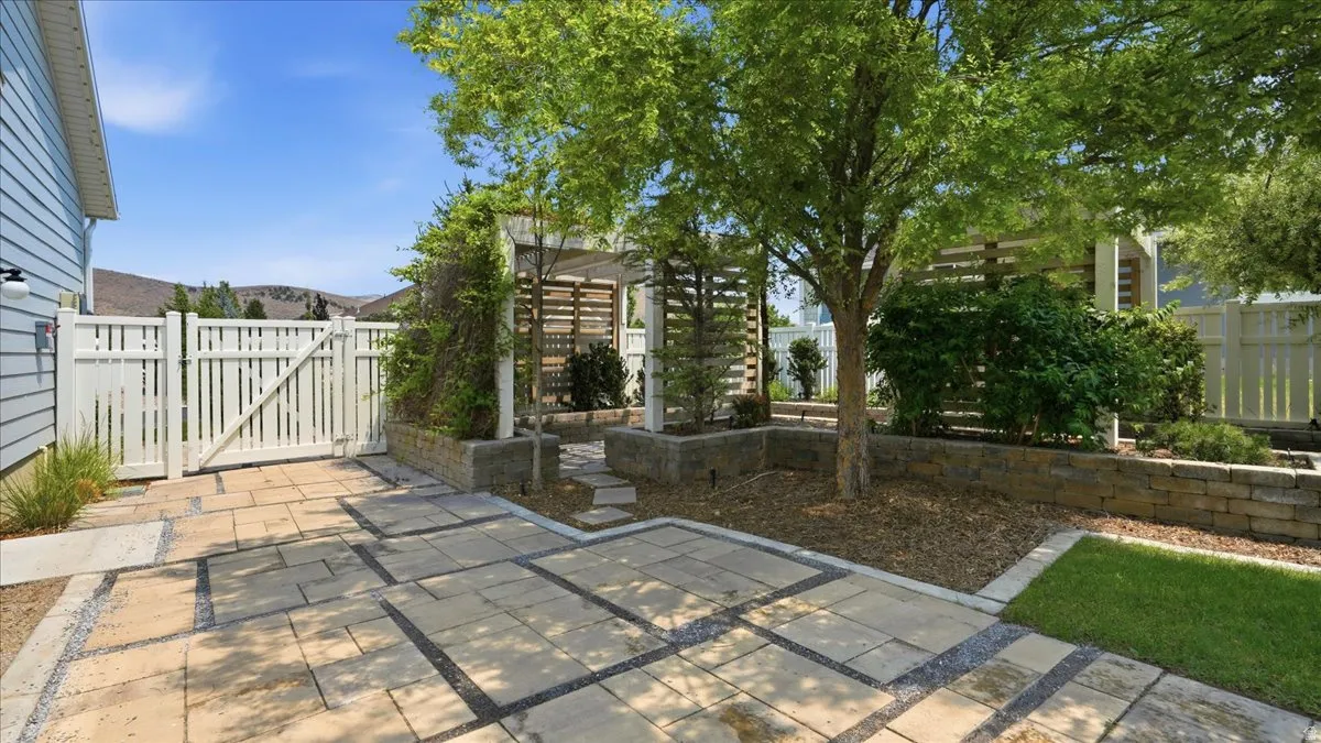 Expansive paved patio featuring square concrete pavers and dark gravel accents