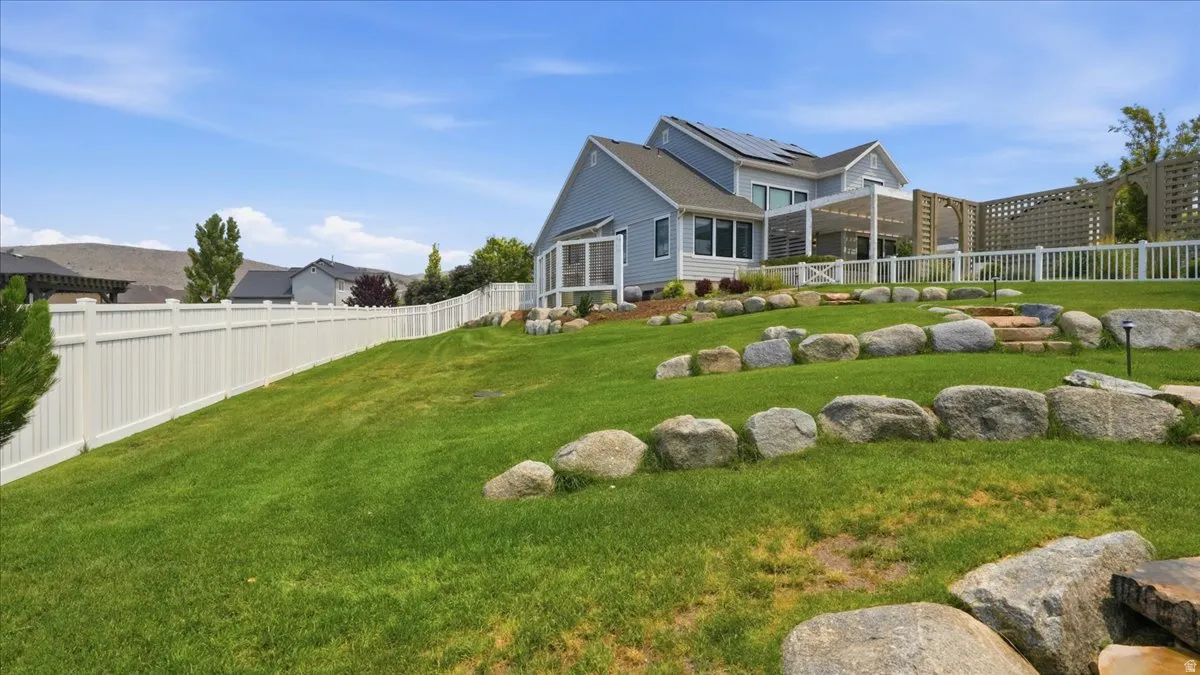 Expansive sloped lawn with decorative rock landscaping
