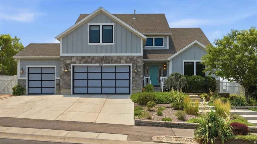 Contemporary multi-level residence featuring a combination of horizontal siding, vertical board and batten siding, and stone veneer accents