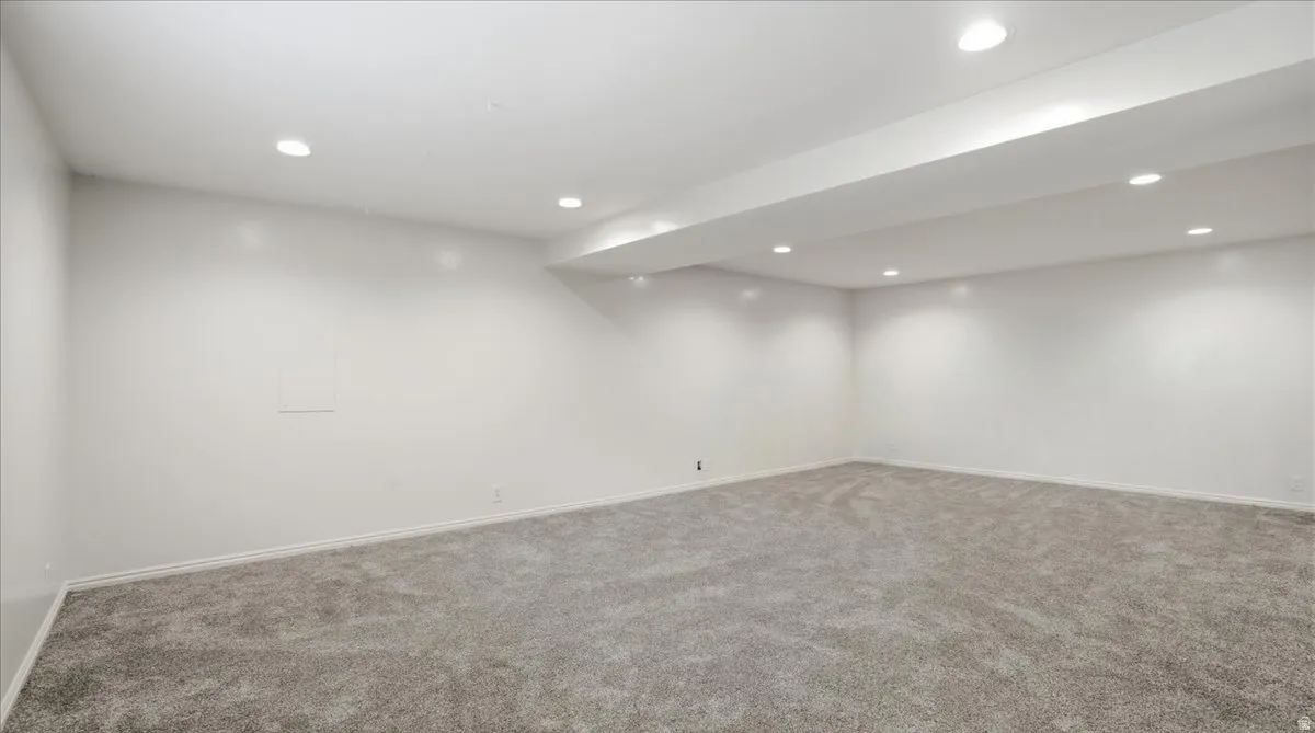 Spacious room featuring neutral paint, recessed lighting, and soft grey carpeting