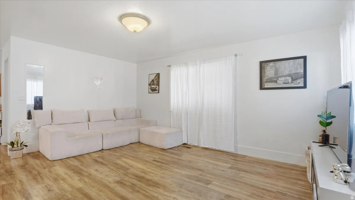 Bright interior space featuring wood-finish flooring, white walls, and a recessed ceiling light fixture