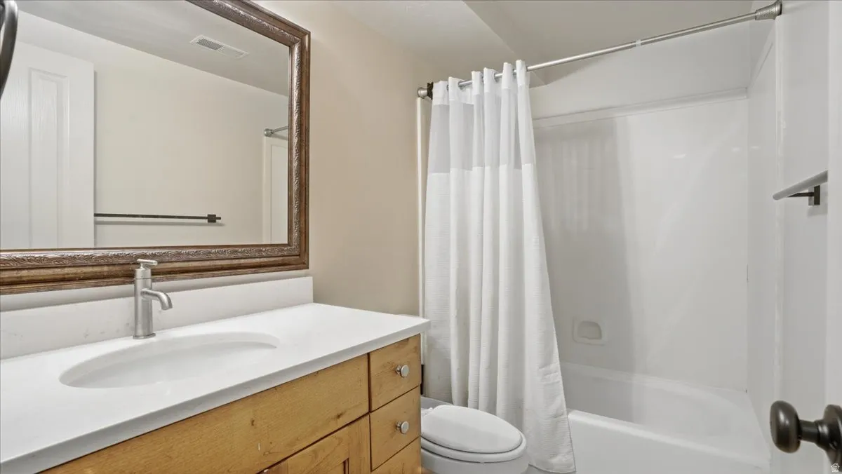 Bathroom featuring a vanity with wood-finish cabinetry, a white countertop, and an undermount sink