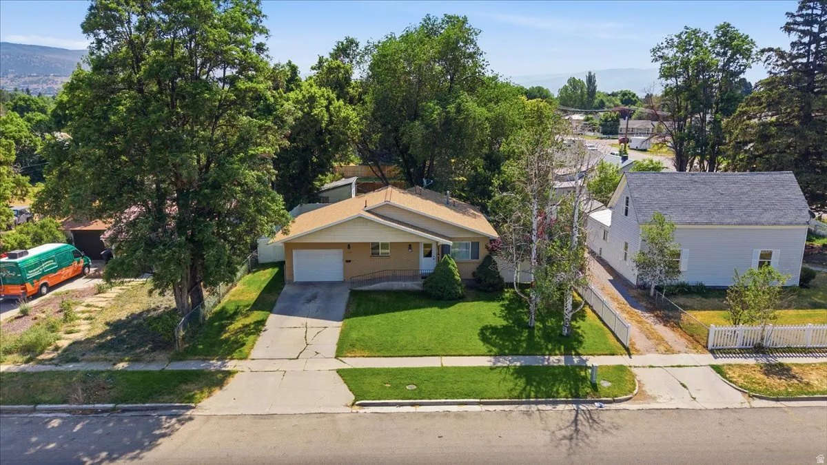Single-story residence featuring a front lawn, attached garage, and concrete driveway