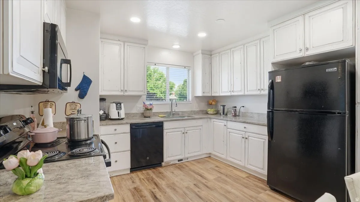 Kitchen featuring white cabinetry and wood-finish flooring
