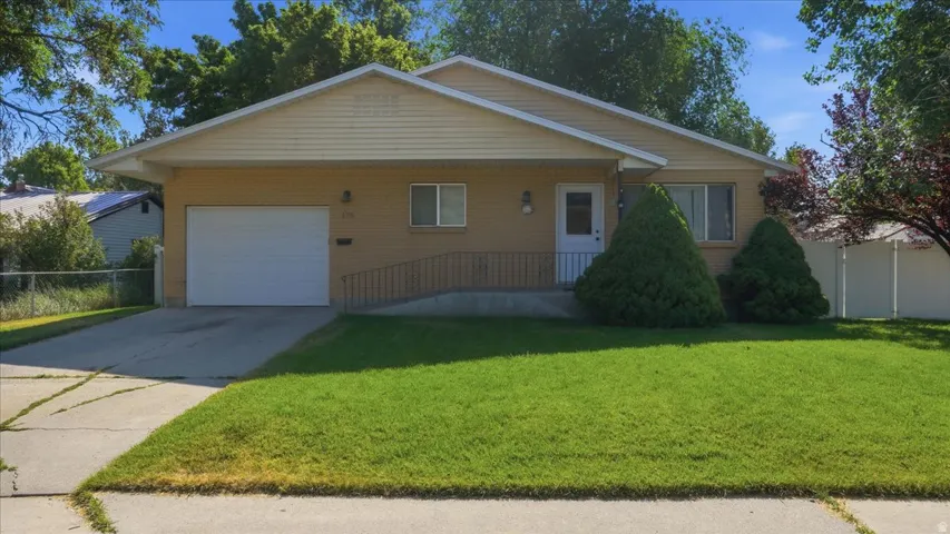 Brick and siding exterior featuring an attached garage and a concrete driveway