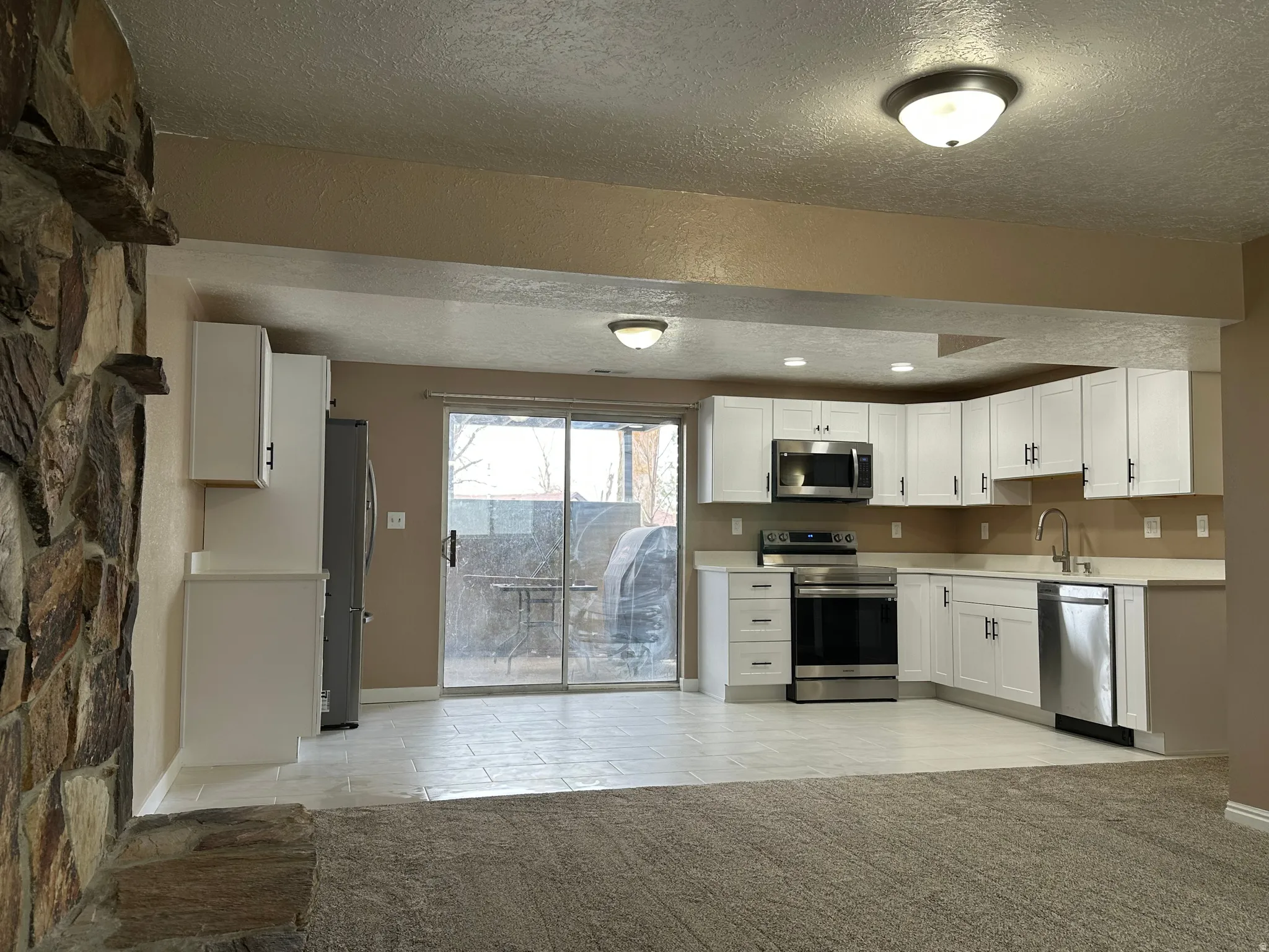 Modern kitchen featuring white cabinetry, stainless steel appliances, and light-toned countertops