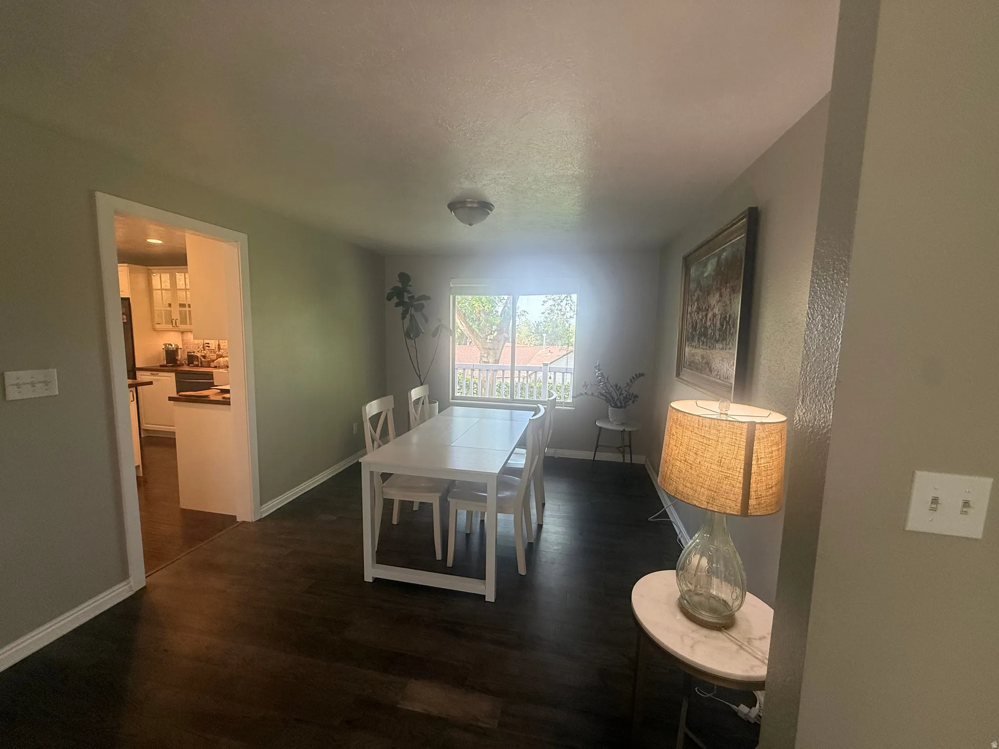 Dining area featuring dark wood-finish flooring and a window providing natural light