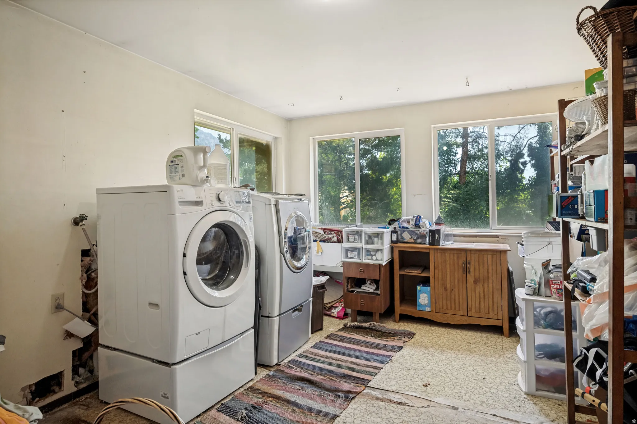 Utility room featuring multiple windows, a wood-finish cabinet, and built-in shelving