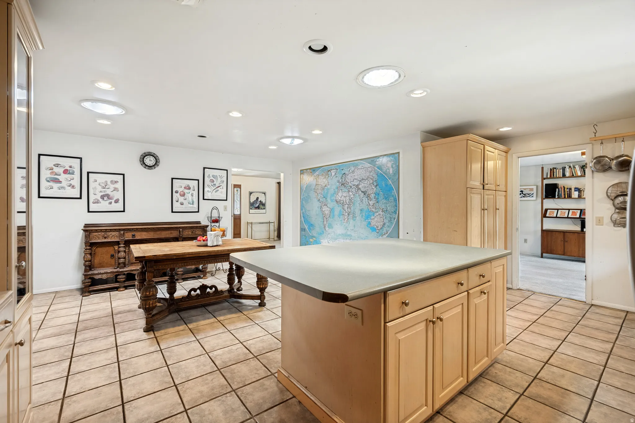 Kitchen featuring a central island with a solid surface countertop, recessed lighting, skylights, extensive cabinetry, and tile flooring