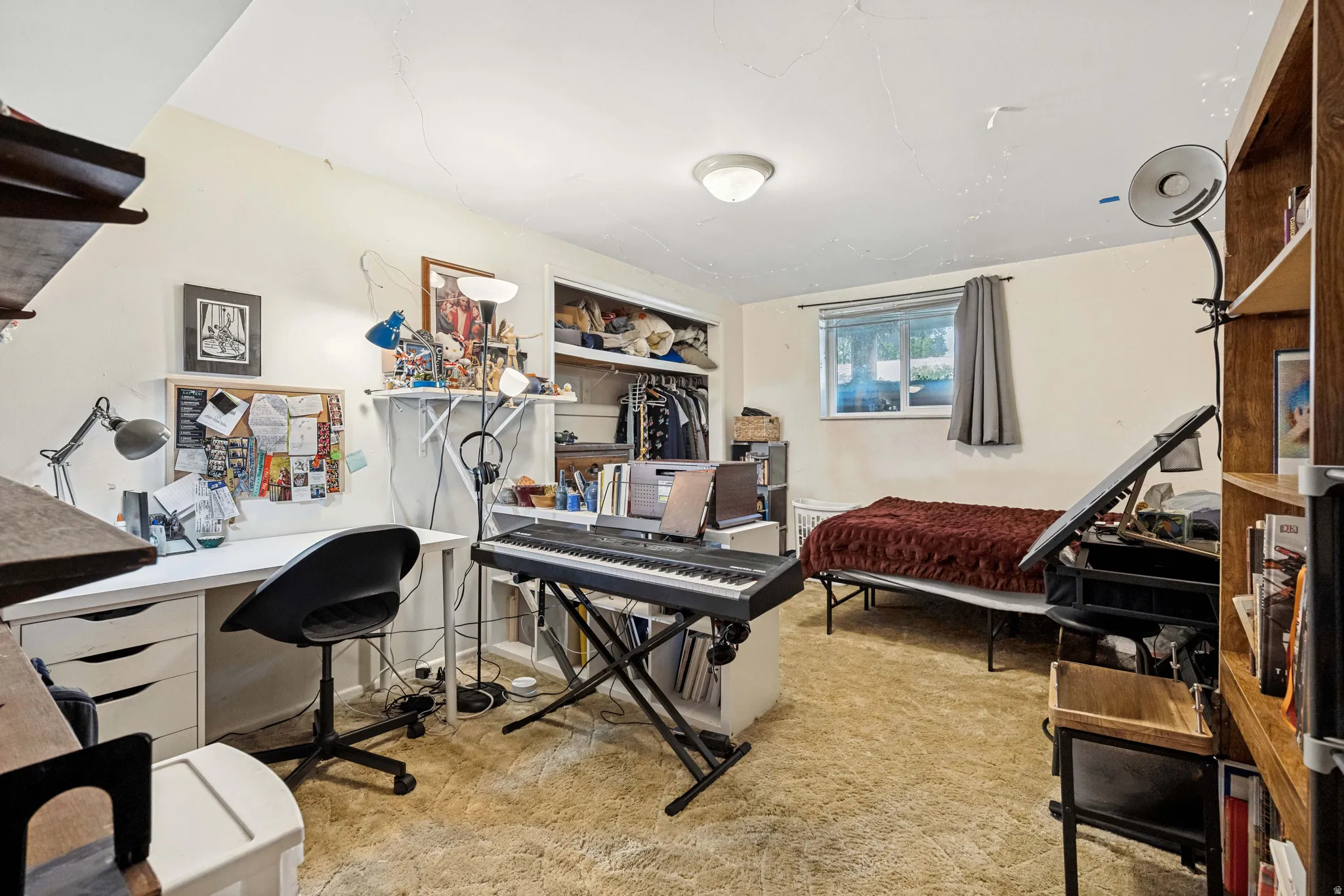 Carpeted room featuring a built-in closet, a window with natural light, and a ceiling-mounted light fixture