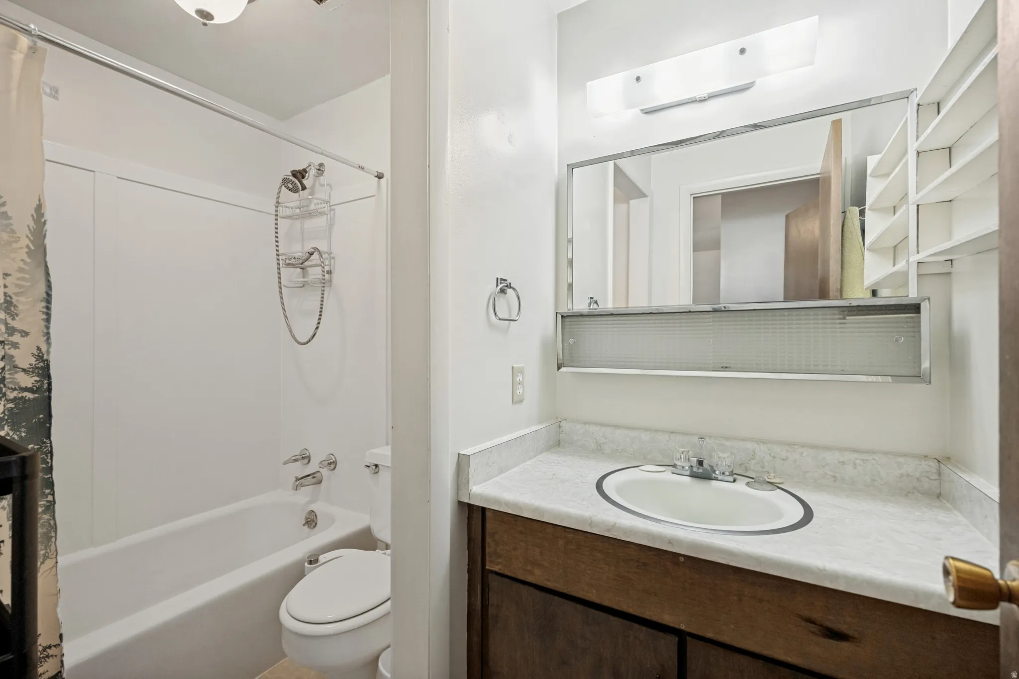 Bathroom featuring a vanity with a laminate countertop, integrated sink, and an overhead mirrored medicine cabinet with lighting