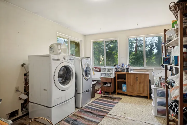 Utility room featuring multiple windows, a wood-finish cabinet, and built-in shelving