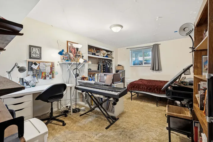Carpeted room featuring a built-in closet, a window with natural light, and a ceiling-mounted light fixture