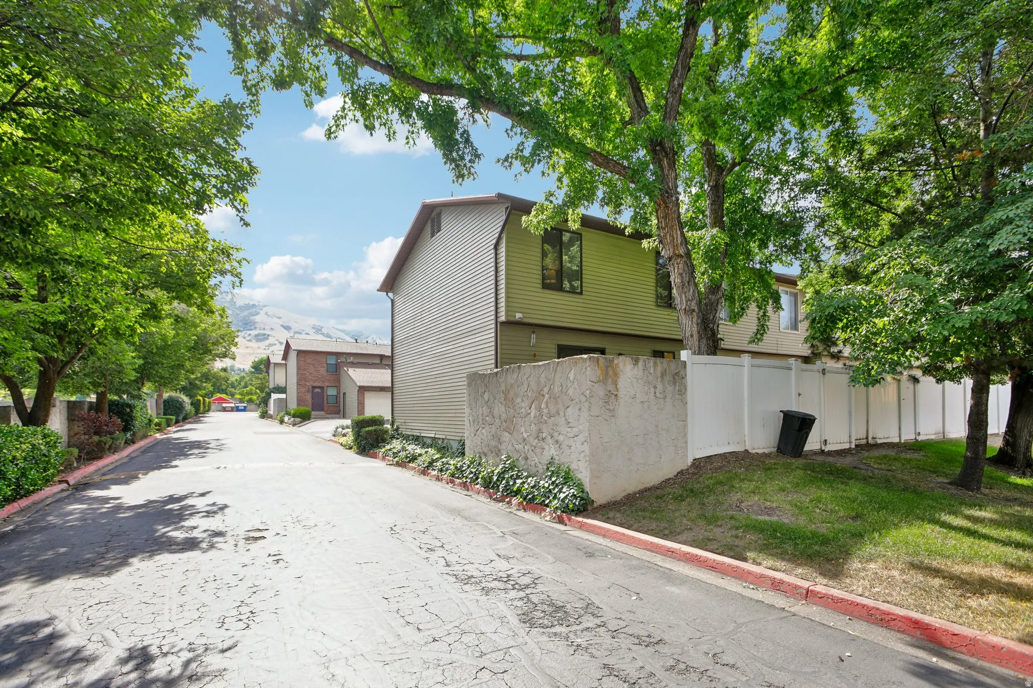 Multi-story residential building with light green siding and brown trim