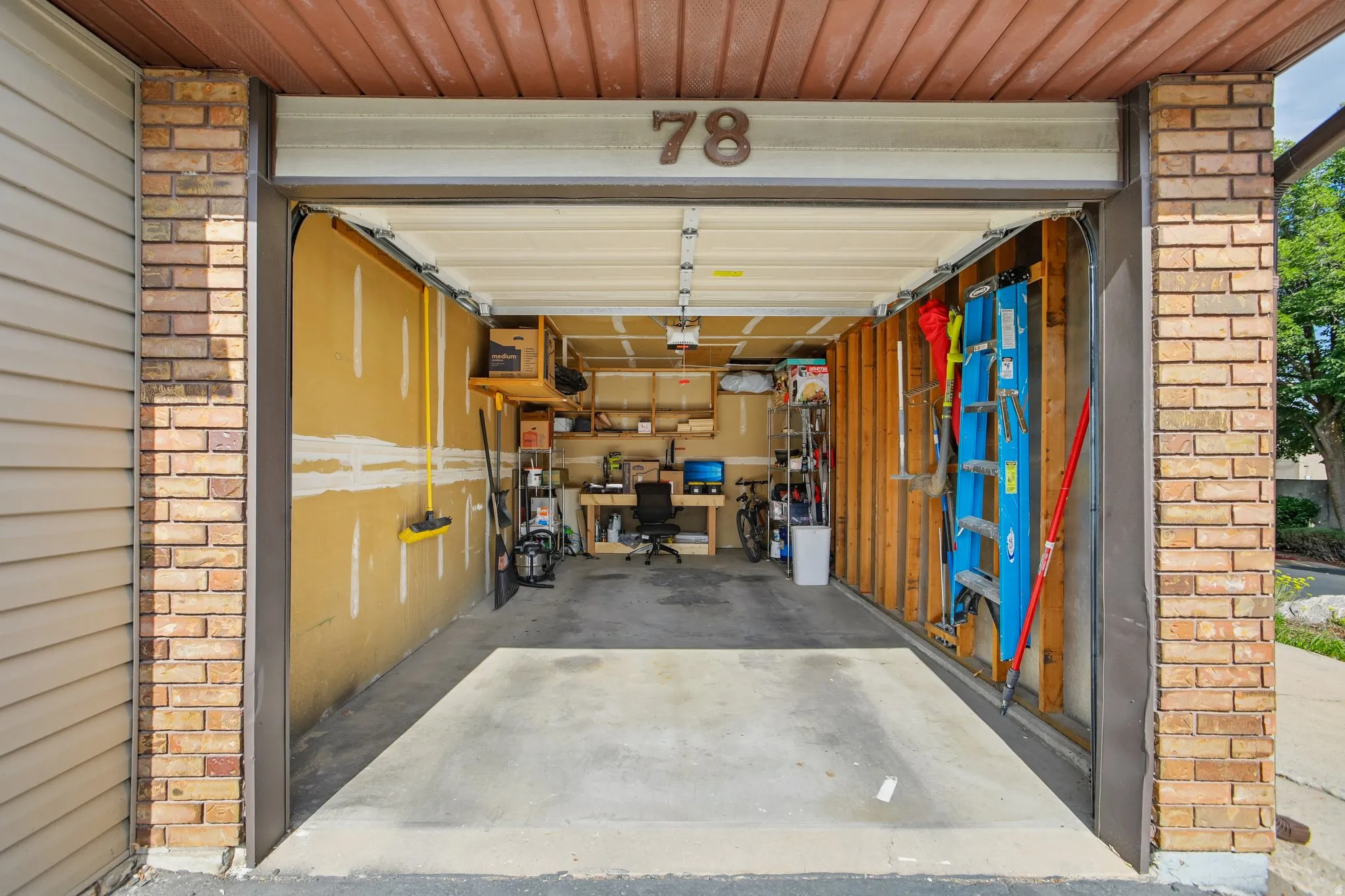 Attached garage with concrete flooring and exposed framing