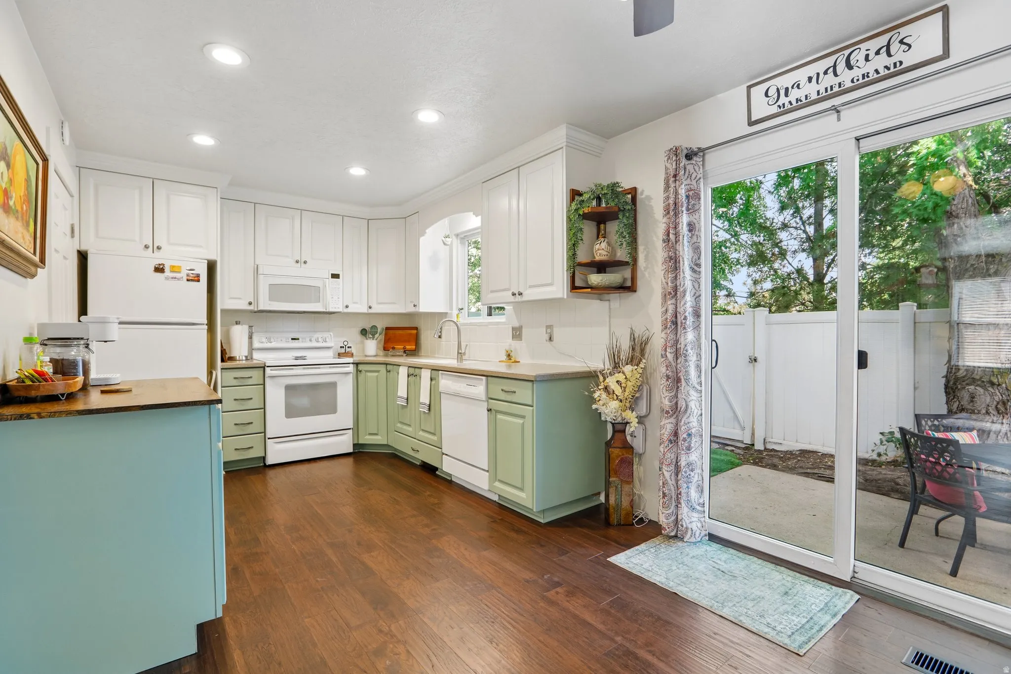 Kitchen featuring wood-finish flooring, white upper cabinetry, and green lower cabinetry