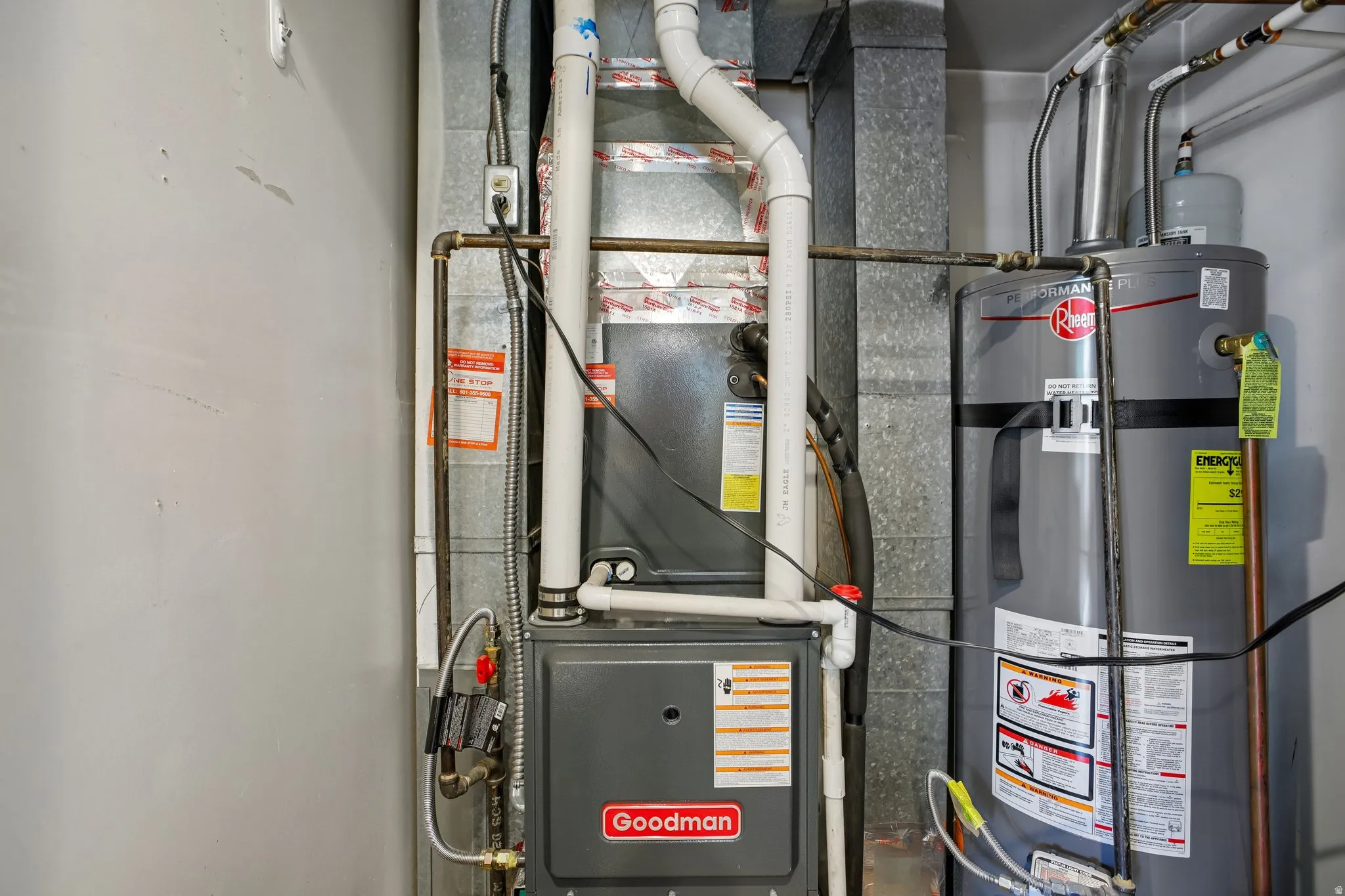 Utility area featuring a Rheem water heater and Goodman furnace