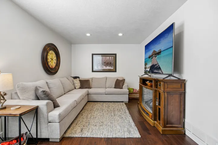 Spacious living area featuring wood-finish flooring and light-toned walls