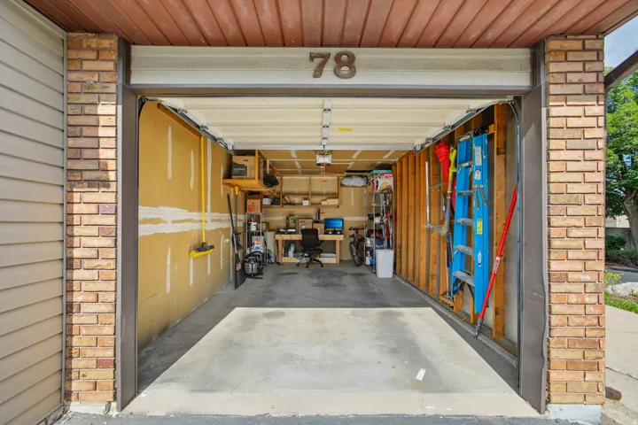 Attached garage with concrete flooring and exposed framing