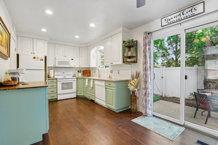 Kitchen featuring wood-finish flooring, white upper cabinetry, and green lower cabinetry