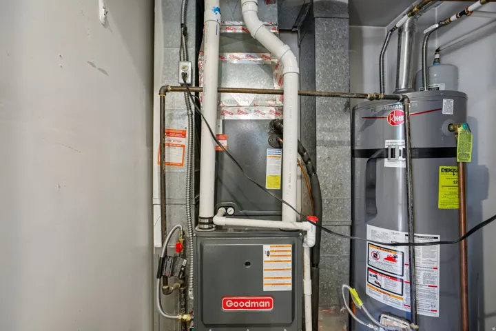 Utility area featuring a Rheem water heater and Goodman furnace