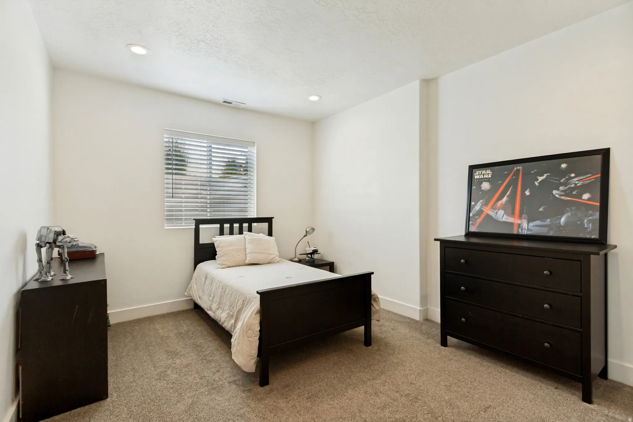 Carpeted room with recessed lighting and a window featuring horizontal blinds
