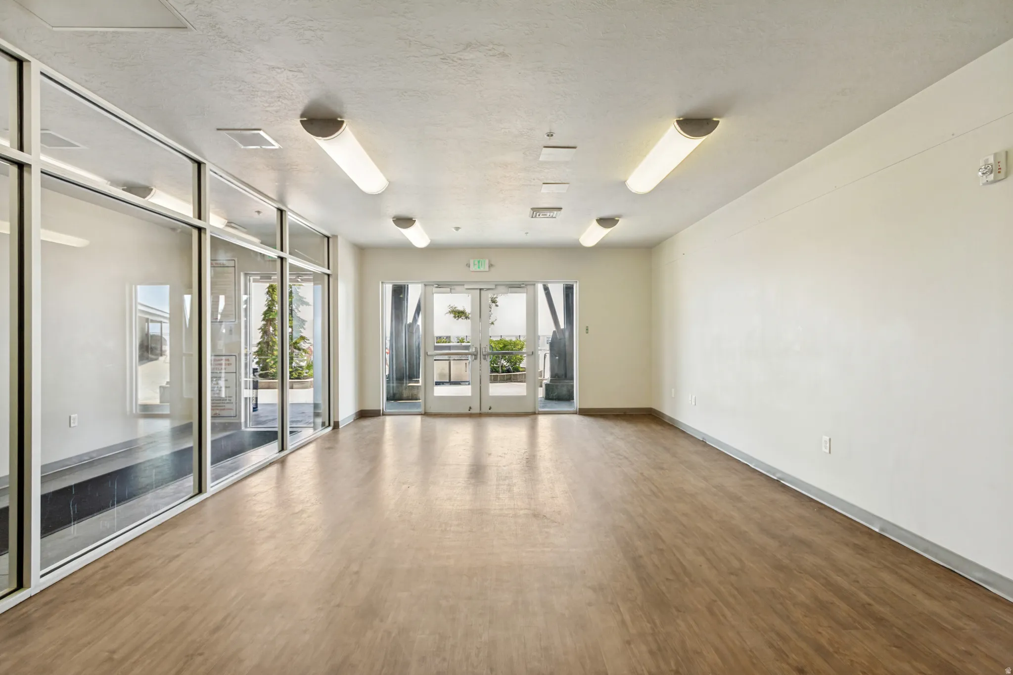 Spacious interior featuring wood-finish flooring, white walls, and contemporary flush-mount lighting