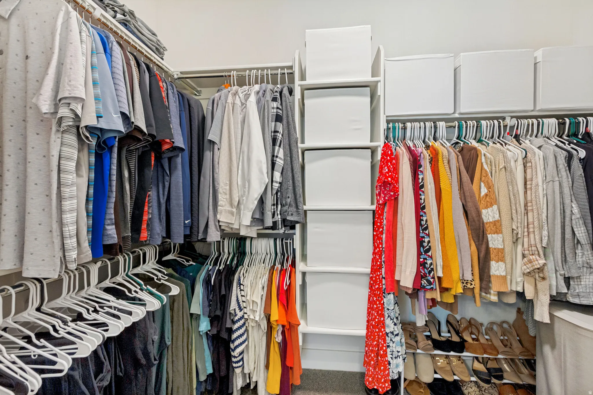 Custom closet system featuring multiple hanging rods, integrated shelving, and dedicated shoe storage
