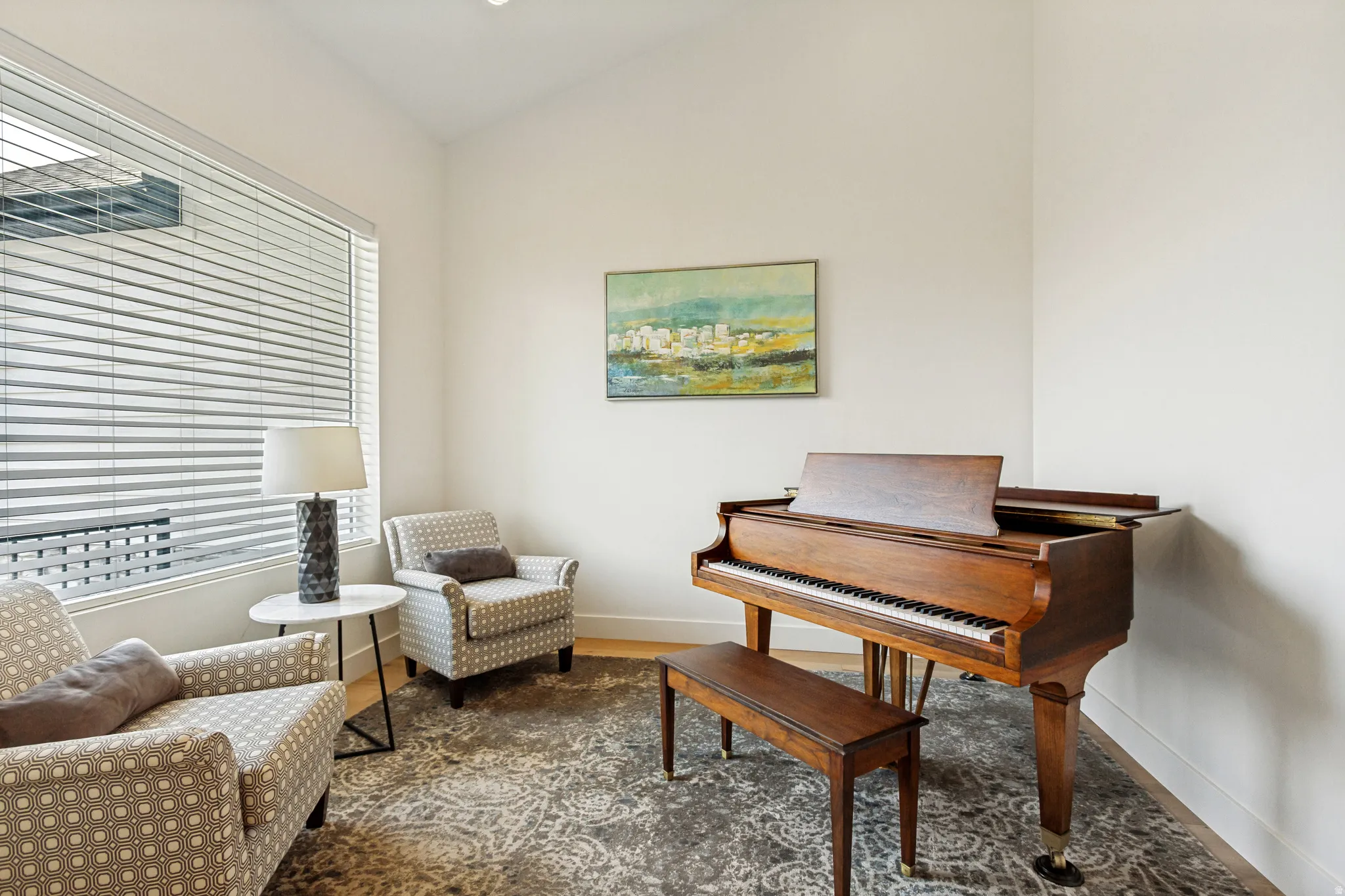 Bright room featuring a large window with horizontal blinds, wood-finish flooring, and a recessed light fixture