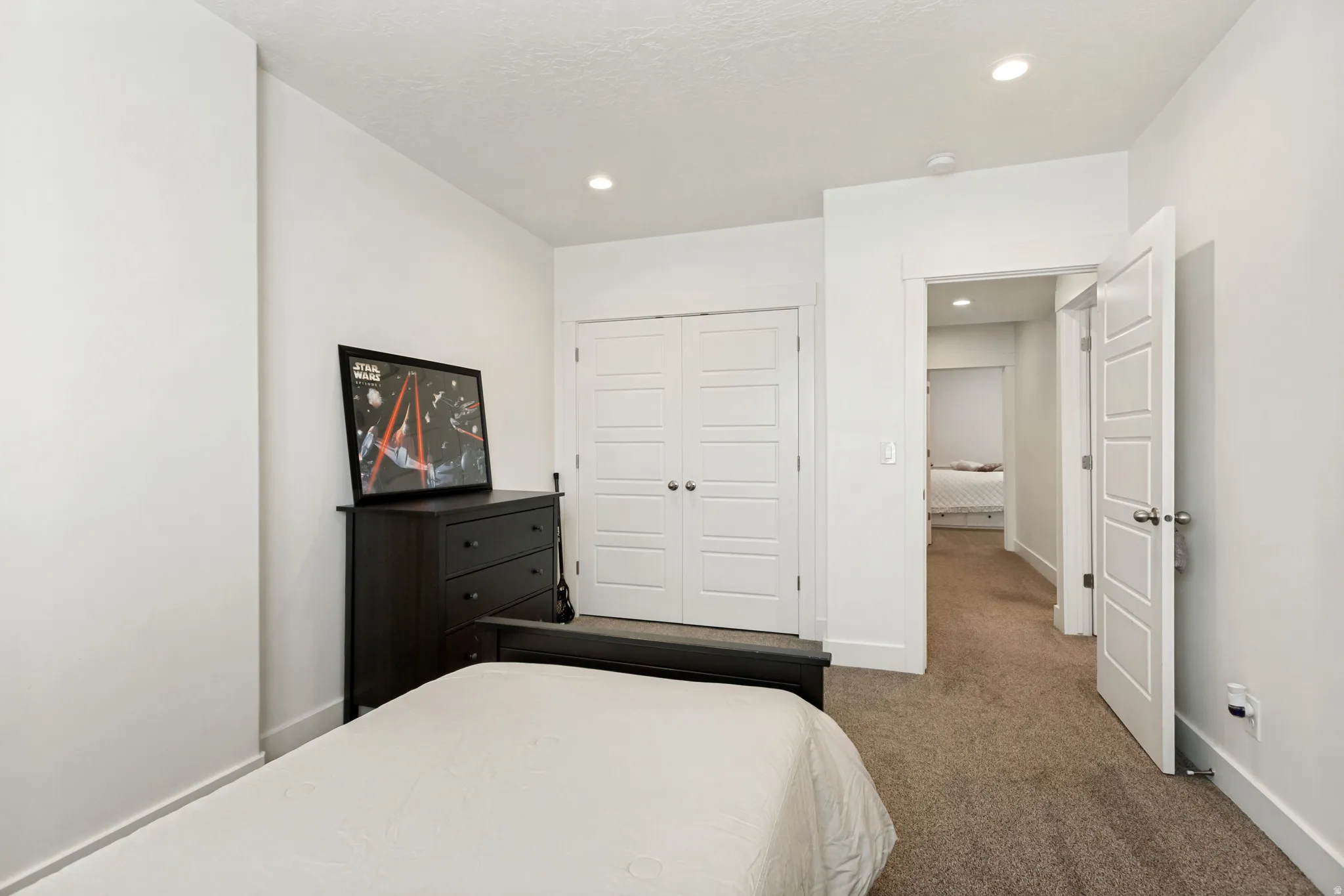 Bright bedroom featuring recessed lighting and neutral-toned carpet flooring