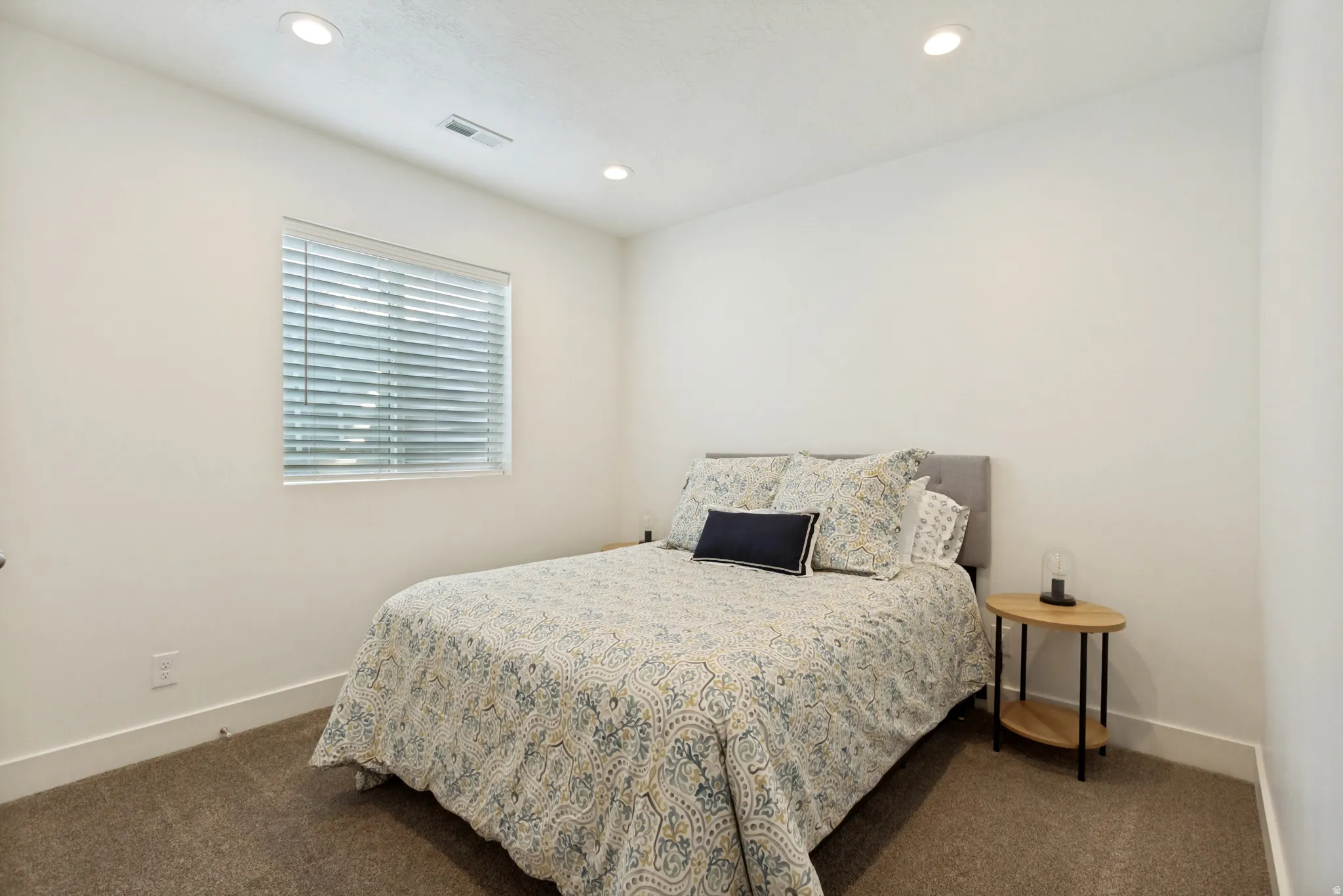 Room featuring recessed ceiling lighting, a window with horizontal blinds, neutral wall paint, and carpet flooring
