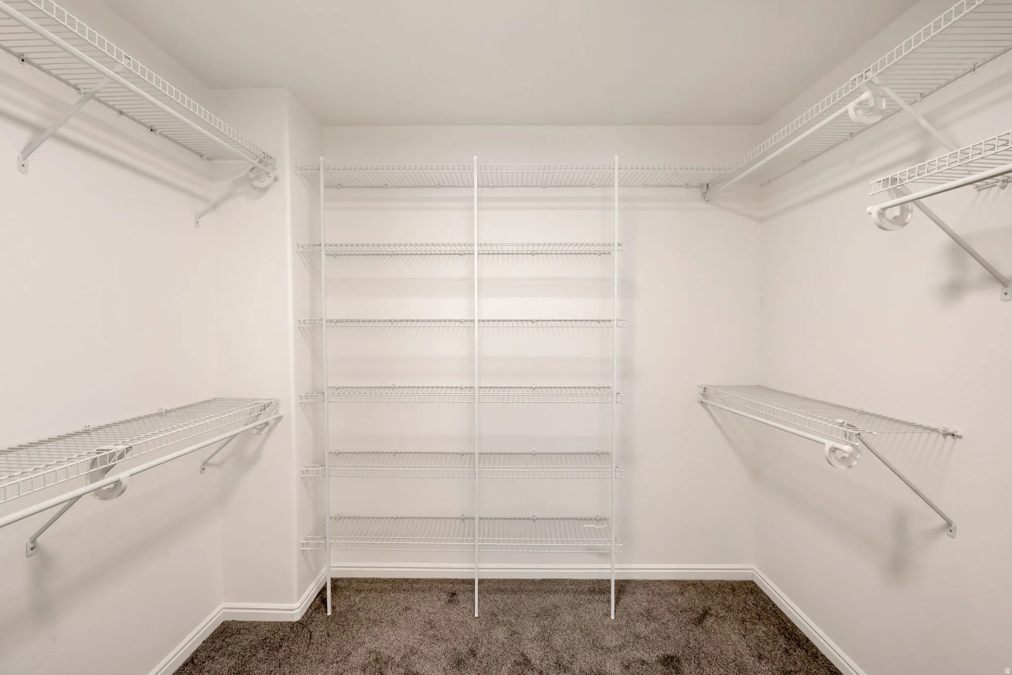 Walk-in closet featuring extensive wire shelving and hanging rods