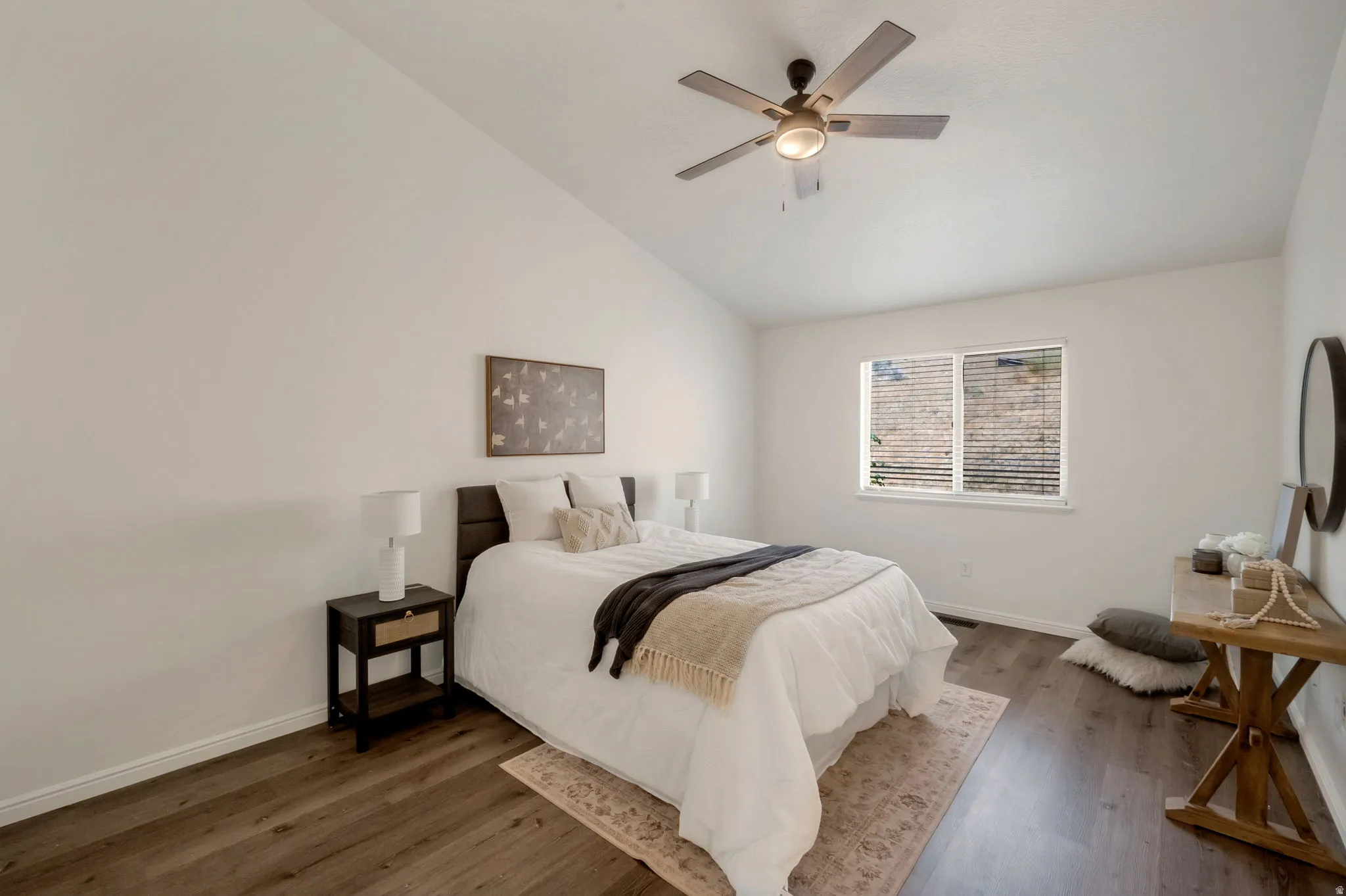 Bedroom featuring a vaulted ceiling with a ceiling fan, wood-finish flooring, and a window with horizontal blinds