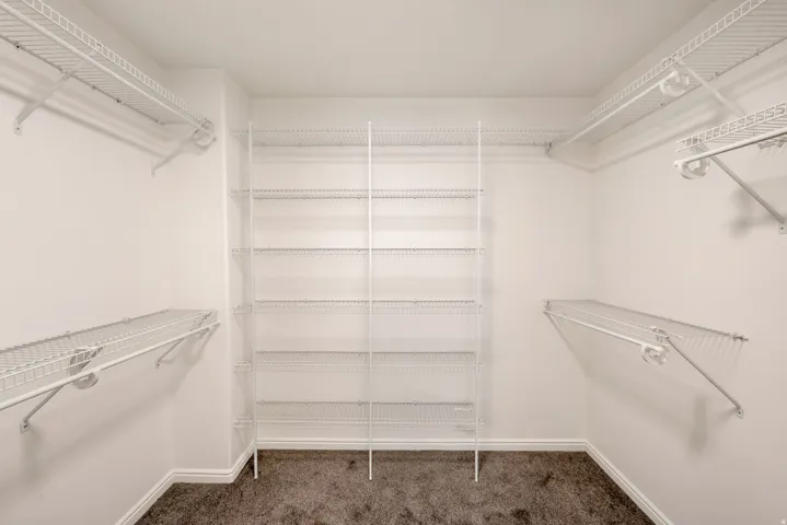 Walk-in closet featuring extensive wire shelving and hanging rods