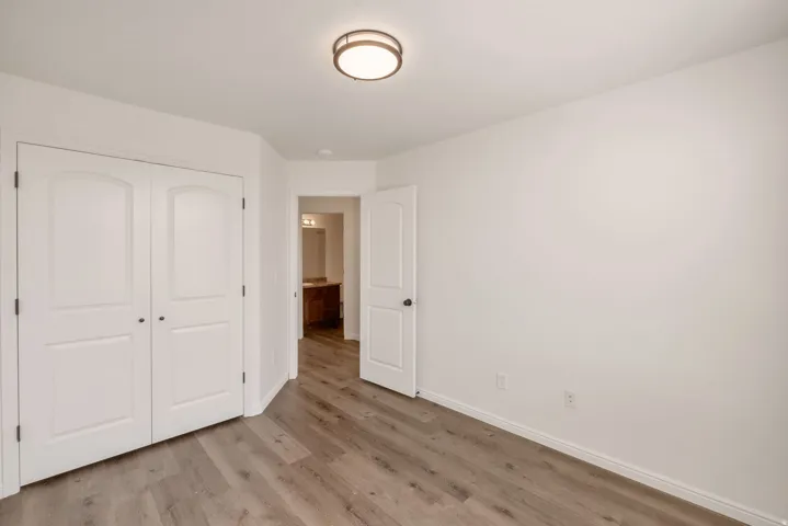 Room featuring wood-finish flooring, white walls, and a flush-mount ceiling light