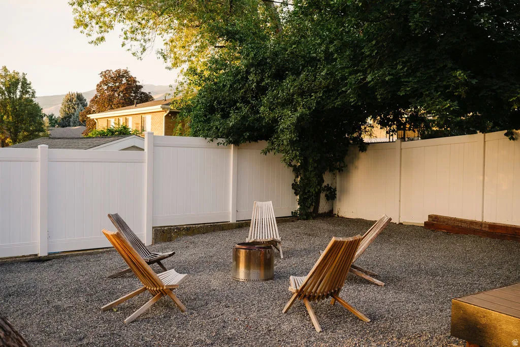 Gravel yard featuring white panel fencing and mature landscaping